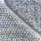 KnitPal Chenillique XL chenille yarn in Blue Whisper, close-up swatch half knit half crochet showing plush blue-gray texture.