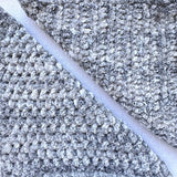 KnitPal Chenillique XL chenille yarn in Clouded Ink, close-up swatch half knit half crochet showing plush gray-and-white texture.