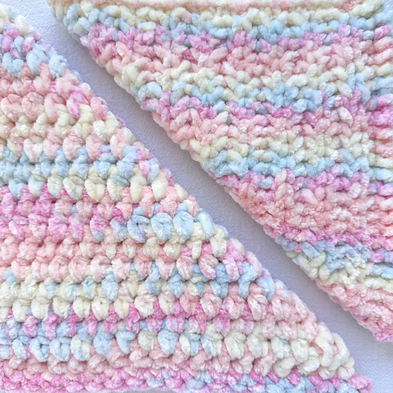 KnitPal Chenillique XL chenille yarn in Pastel Dreams, close-up swatch half knit half crochet showing plush pink, blue, and cream texture