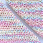 KnitPal Chenillique XL chenille yarn in Pastel Dreams, close-up swatch half knit half crochet showing plush pink, blue, and cream texture