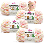 KnitPal Chenillique XL super bulky chenille yarn in Peach Fizz pink, peach, and cream colorway, four skeins with crochet bear plushie.