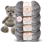 Four skeins of KnitPal Chenillique Cub Brown worsted weight chenille yarn stacked with a crocheted teddy bear amigurumi