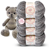 Four skeins of KnitPal Chenillique Cub Brown worsted weight chenille yarn stacked with a crocheted teddy bear amigurumi