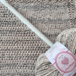 KnitPal Chenillique Cub Brown chenille yarn swatch showing knit and crochet texture side by side in warm taupe with dark flecks