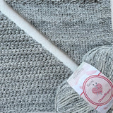 KnitPal Chenillique Ocean Mist chenille yarn swatch showing knit and crochet texture side by side in cool heathered gray with dark flecks