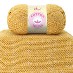 Cotton Bliss yarn skein in Golden Amber on knitted swatch