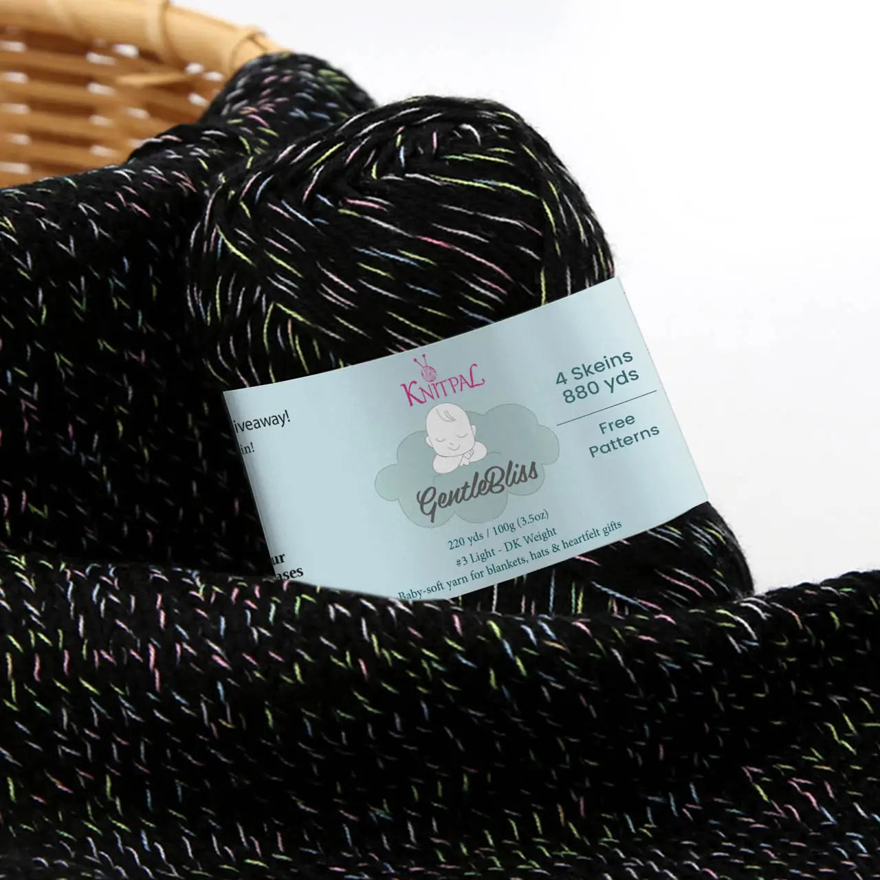 KnitPal GentleBliss DK weight yarn in black with multicolor marl flecks, two skeins on knitted fabric swatch, label visible