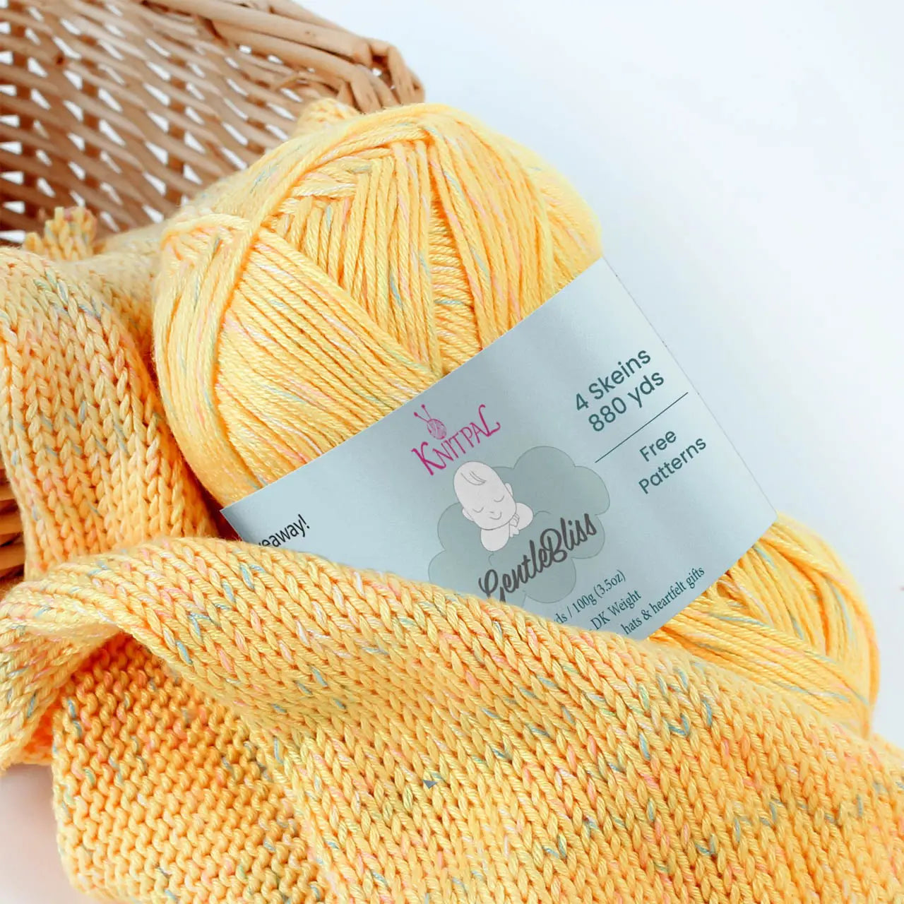 KnitPal GentleBliss DK weight yarn in soft sunny yellow with multicolor marl flecks, skein on knitted fabric swatch, label visible