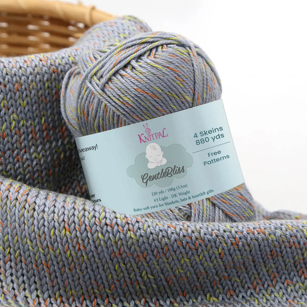 KnitPal GentleBliss DK weight yarn in medium gray with orange and yellow-green marl flecks, skein on knitted fabric swatch, label visible