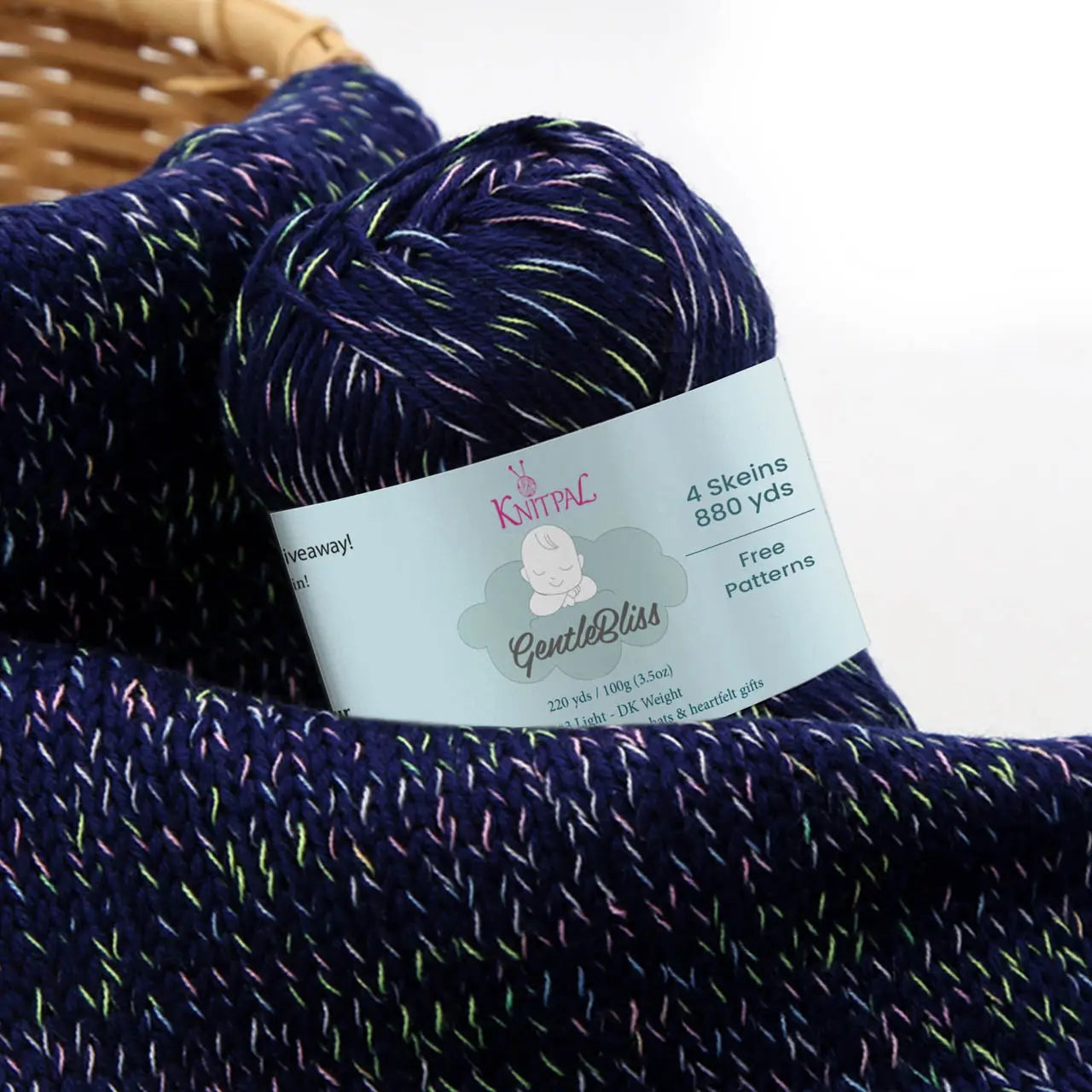KnitPal GentleBliss DK weight yarn in rich navy blue with multicolor marl flecks, skein on knitted fabric swatch, label visible